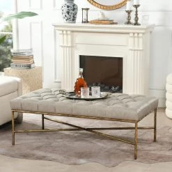 Aerin Warm Gray Faux Leather Hammered Gold Tufted Cocktail Ottoman 25 in. x 48.5 in. x 17.5 in. by Jennifer Taylor